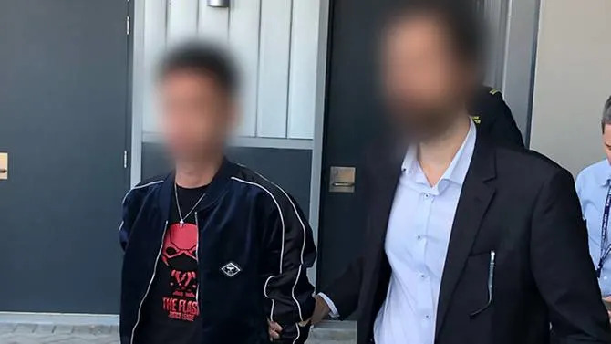 The Malaysian man being taken into custody at Perth Airport on March 15 after child exploitation material was allegedly found on his mobile phone. — Australian Border Force photo