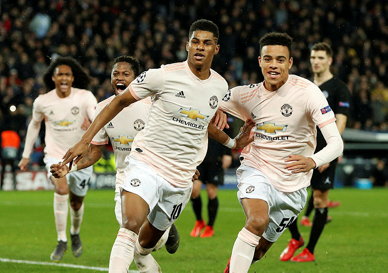 Marcus Rashford (L) reels away in delight after successfully slotting his spot-kick agains PSG. — AFP