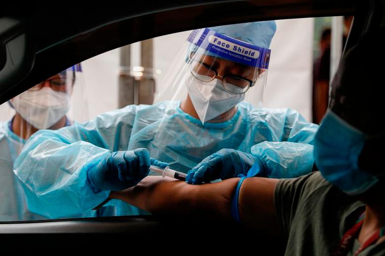 A healthcare worker takes blood sample from a passenger at a coronavirus disease (Covid-19) drive-thru testing center in Manila, Philippines, July 15, 2020. — Reuters