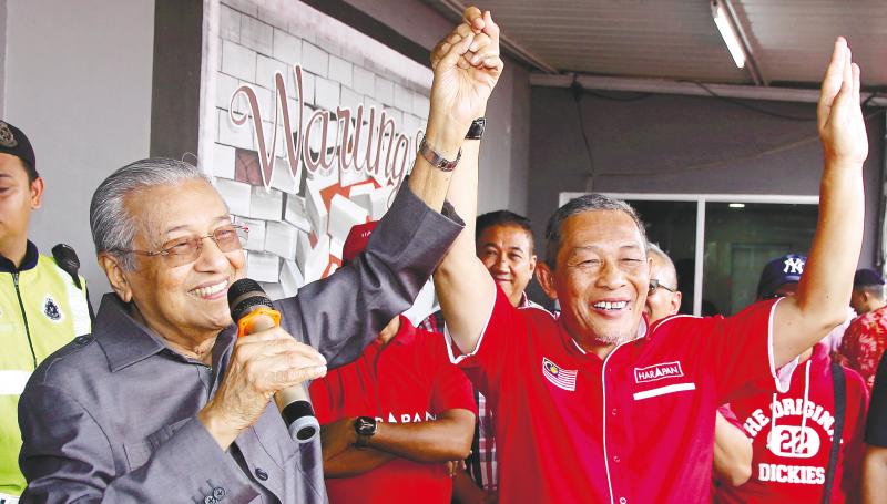 Mahathir raising the hand of Karmaine to show his support during his ceramah, on Nov 15, 2019. — Bernama