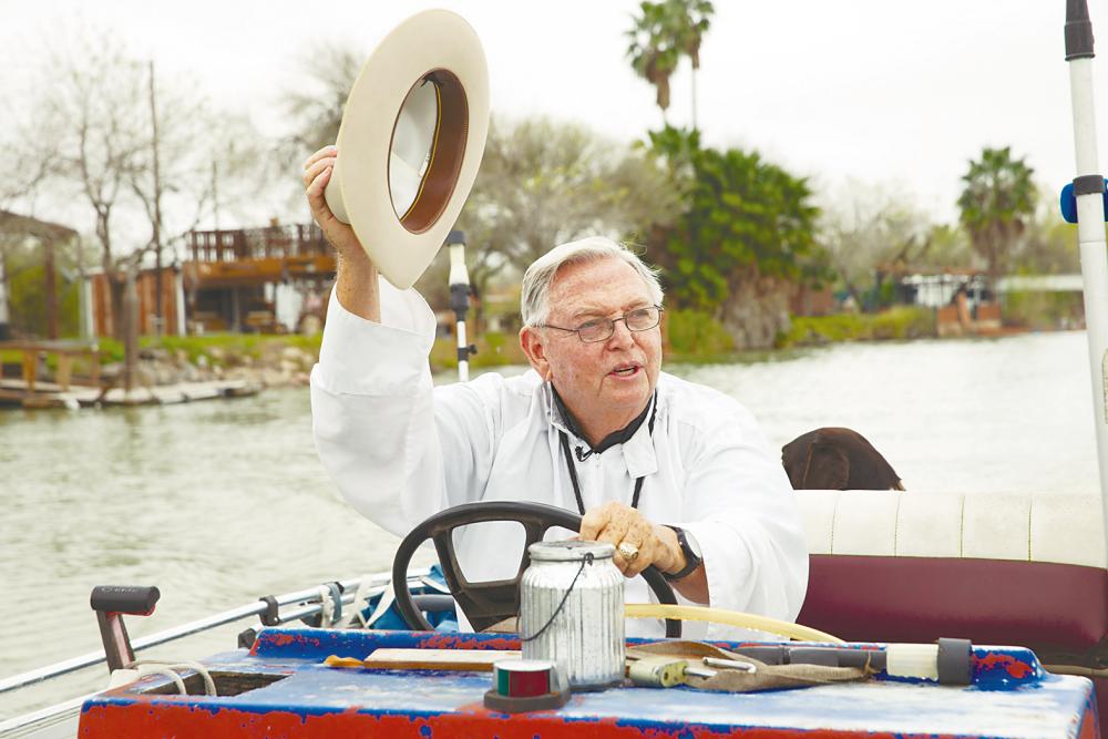 Father Roy Snipes of La Lomita Chapel waves his Stetson to locals as he drives his boat along the Rio Grande last Wednesday in Mission, Texas. For Snipes, who has lived here for 26 years, building the wall would “desecrate a sacred place”. The Catholic Diocese of Brownsville is fighting the government’s plan to take the chapel of this historic mission as part of the border wall. AFP