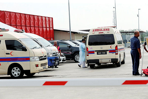 Ambulances wait outside the chicken processing factory which experienced an ammonia gas leak in Merlimau today. — BBXpress