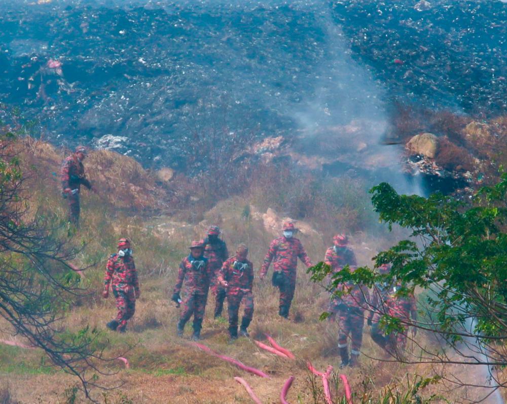 NIBONG TEBAL, JAN 20 - Malaysian Fire and Rescue (JBPM) personnel descended from the Pulau Burung garbage fire extinguishing operation site, through the hillside today. MASRY CHE ANI/THESUN