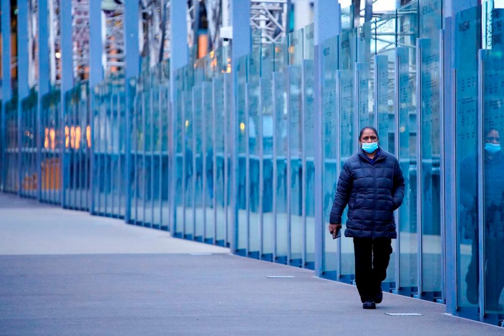 A woman wearing a protective face mask walks along a deserted city bridge during morning commute hours on the first day of a lockdown as the state of Victoria looks to curb the spread of a coronavirus disease (Covid-19) outbreak in Melbourne, Australia, July 16, 2021. REUTERSpix