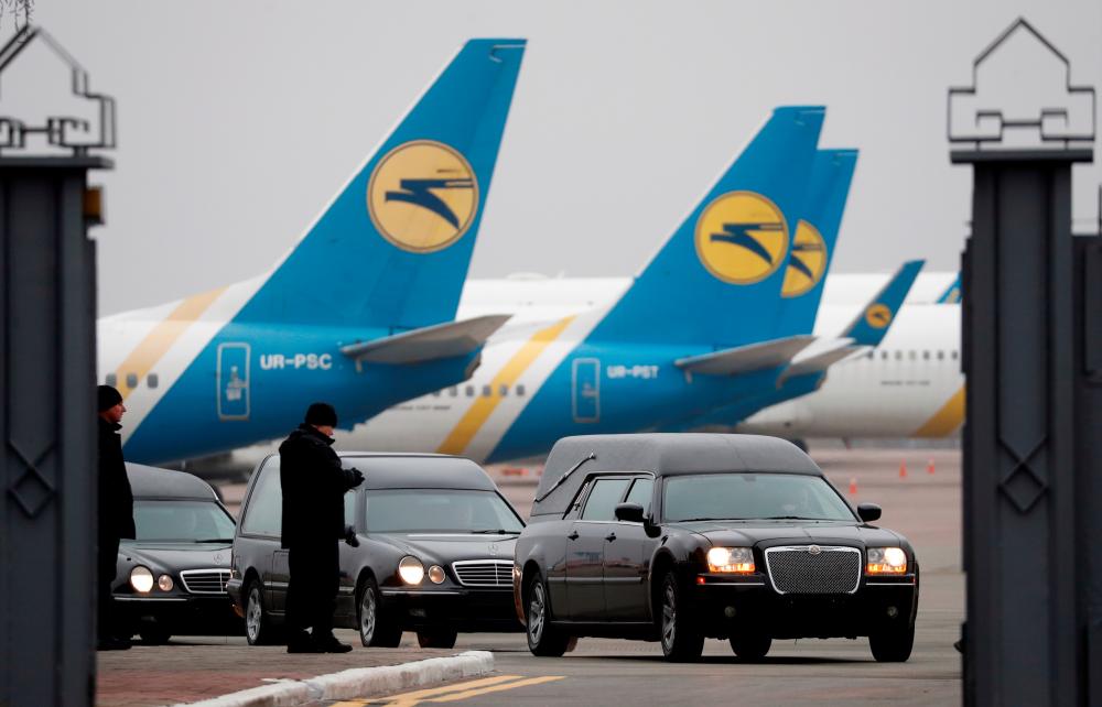 Hearses which carried the bodies of the eleven Ukrainian victims of the Ukraine International Airlines flight 752 plane disaster for a memorial ceremony are seen in front of Ukrainian International Airlines planes at the Boryspil International Airport outside Kiev, Ukraine January 19, 2020. - Reuters