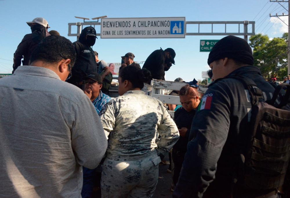 Mexican state agents are held by demonstrators during a demonstration that, according to its organizers, is protesting the government’s failure to carry out road works in three communities in Chilpancingo, Guerrero state, Mexico, on July 11, 2023. AFPPIX