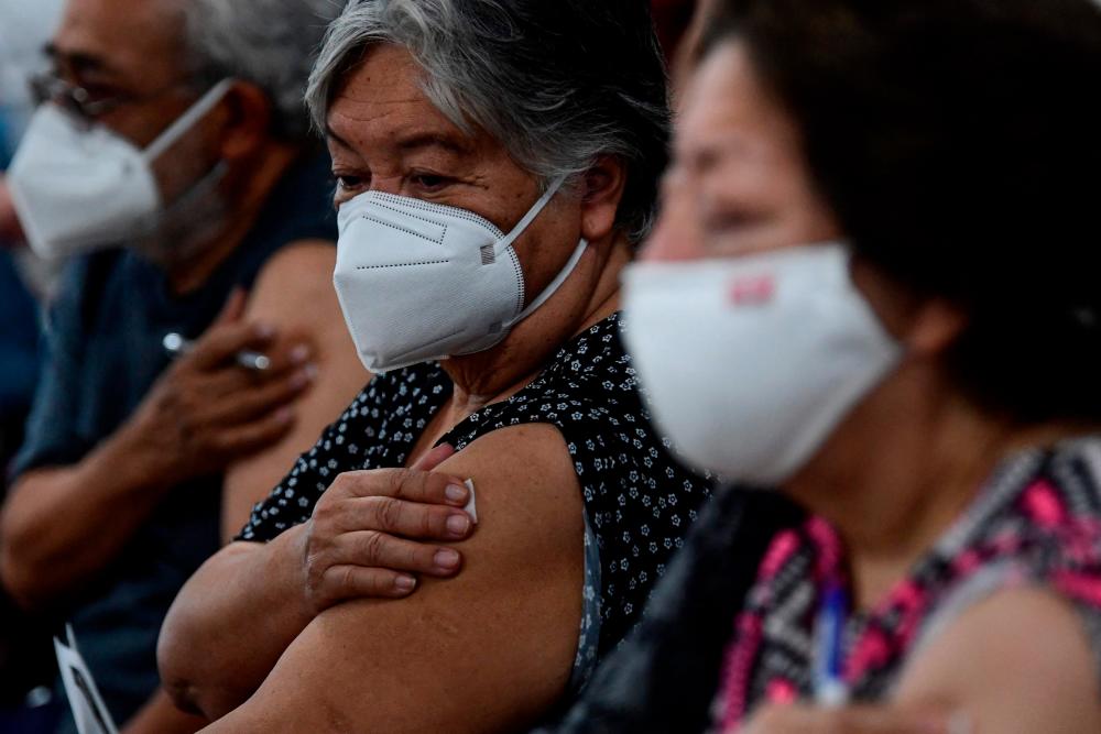 People wait after receiving a dose of the AstraZeneca vaccine against COVID-19 during the first day of the application of the third dose to people over 60 years-old at the Centro de Estudios Superiores Navales (CENCIS) in Mexico City, on December 7, 2021. AFPpix