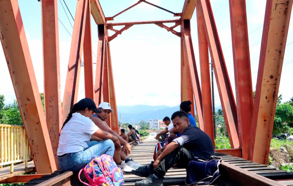 Migrants, rest on a railway bridge in an area in Huixtla before they continue with a caravan, heading to Mexico City to apply for asylum and refugee status, in Huixtla, Mexico October 26, 2021. REUTERSpix