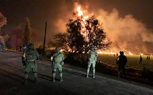 This handout photo distributed by the Mexican Secretary of National Defence shows Mexican soldiers standing guard near a fire after a leaking gas pipeline triggered a blaze in Tlahuelilpan, Hidalgo state, on Jan 18, 2019. — AFP