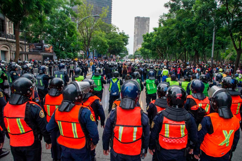 Demonstrators confront riot police in Mexico City on September 26, 2020, during a march for the sixth anniversary of the disappearance of 43 students of the Ayotzinapa Teacher Training College. — AFP