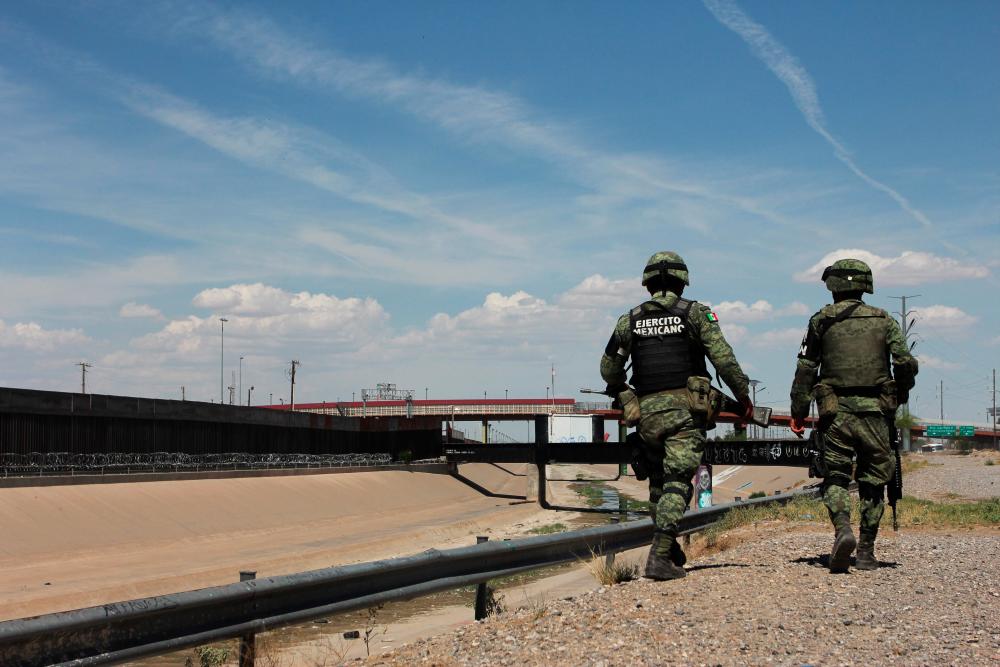 Members of the Mexican National Guard patrol the banks of the Rio Bravo river in Ciudad Juarez, Chihuahua state, Mexico, to prevent illegal crossings across the border river to El Paso Texas, US on July 15, 2019. — AFP
