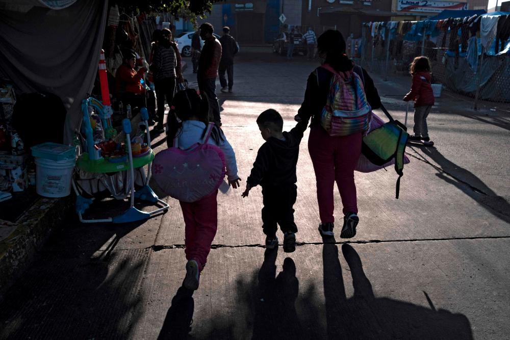 A family arrives at an improvised camp of asylum seekers and refugees at El Chaparral border crossing in Tijuana, Baja California state, Mexico, on December 6, 2021. The United States reimplemented the Migrant Protection Protocol (MPP) program, also known as “Remain in Mexico”, on December 6 after a court order. AFPpix