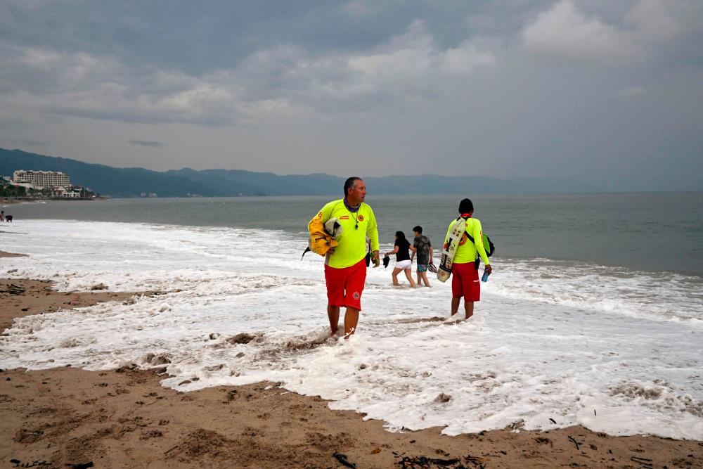 Two members of Civil Protection check the beach ahead of the arrival of Hurricane Roslyn, in the tourist area of Puerto Vallarta, Jalisco State, Mexico, on October 22, 2022. AFPPIX