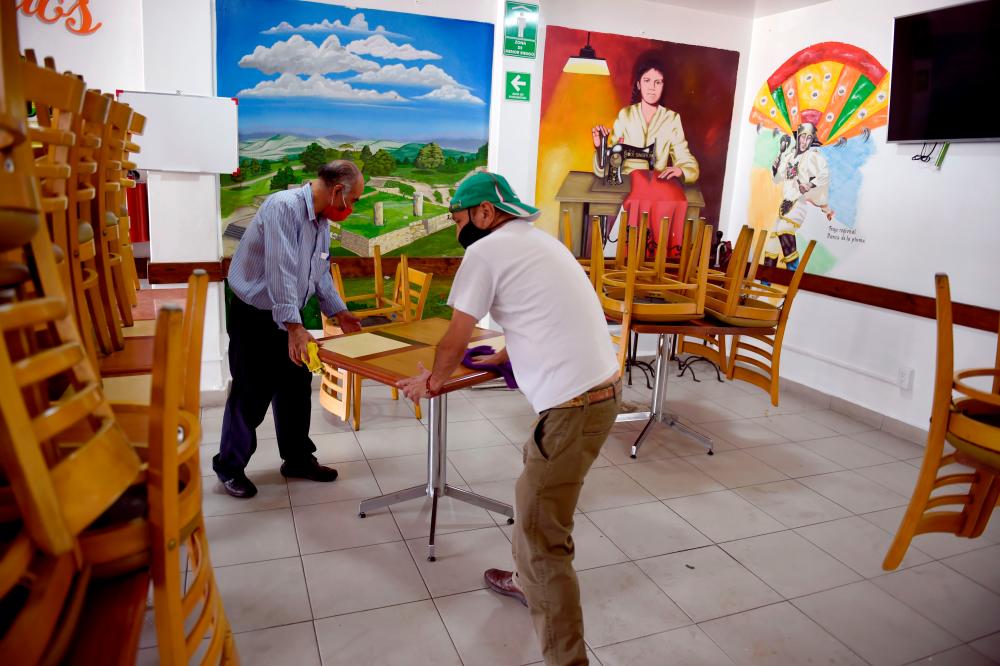 Two employees clean tables at a restaurant in Mexico City. Issues dogging USMCA include legal challenges to Mexico's new labour law to ensure that workers can freely organise and unions are granted full collective bargaining rights. – AFPPIX