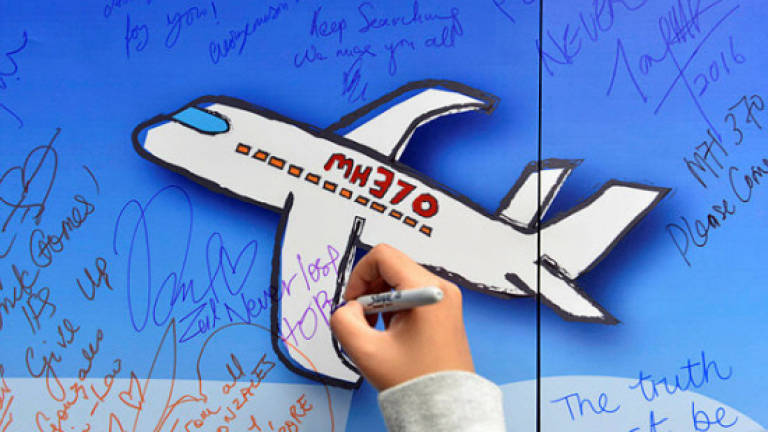 A girl writes messages of hope for passengers of missing Malaysia Airlines Flight MH370 at a remembrance event on the two year anniversary of its disappearance in Publika Kuala Lumpur, March 6, 2016. — Sunpix by Asyraf Rasid