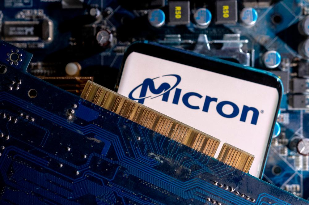 A smartphone with a displayed Micron logo is placed on a computer motherboard in this illustration. – Reuterspic