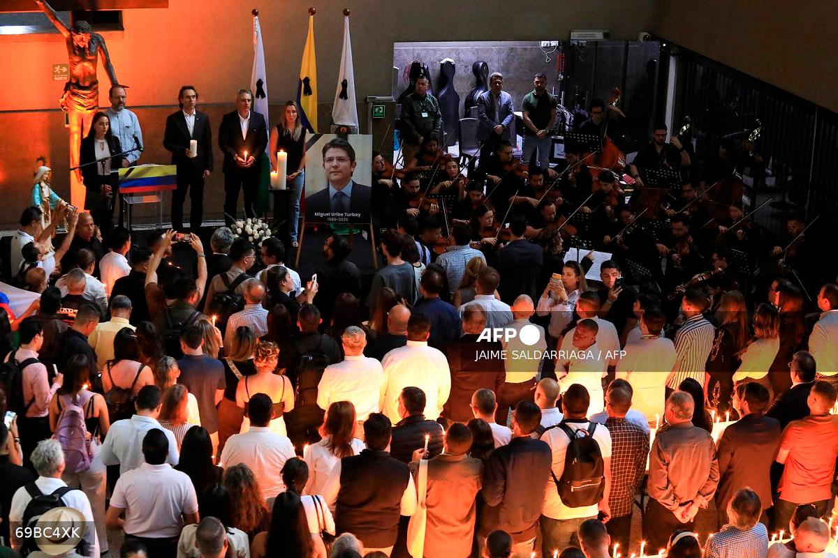 Medellin Mayor Federico Gutierrez (3nd L) and governor of Antioquia Andres Julian Rendon (4nd L) hold candles during a vigil for the death of Colombian presidential candidate Miguel Uribe at the Antioquia governor's office in Medellin, Colombia on August 11, 2025. - JAIME SALDARRIAGA / AFP