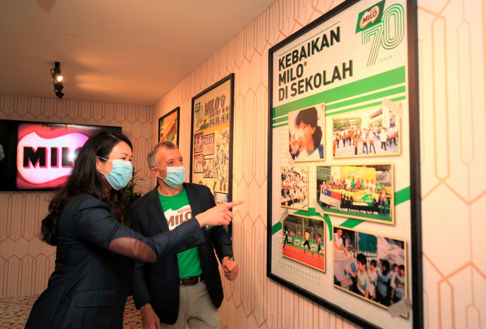 Ng Su Yen, Business Executive Officer, MILO Business Unit (left) and Juan Aranols, Chief Executive Officer, Nestle (Malaysia) Berhad appreciating the photo gallery of past MILO campaigns at Pekan MILO.