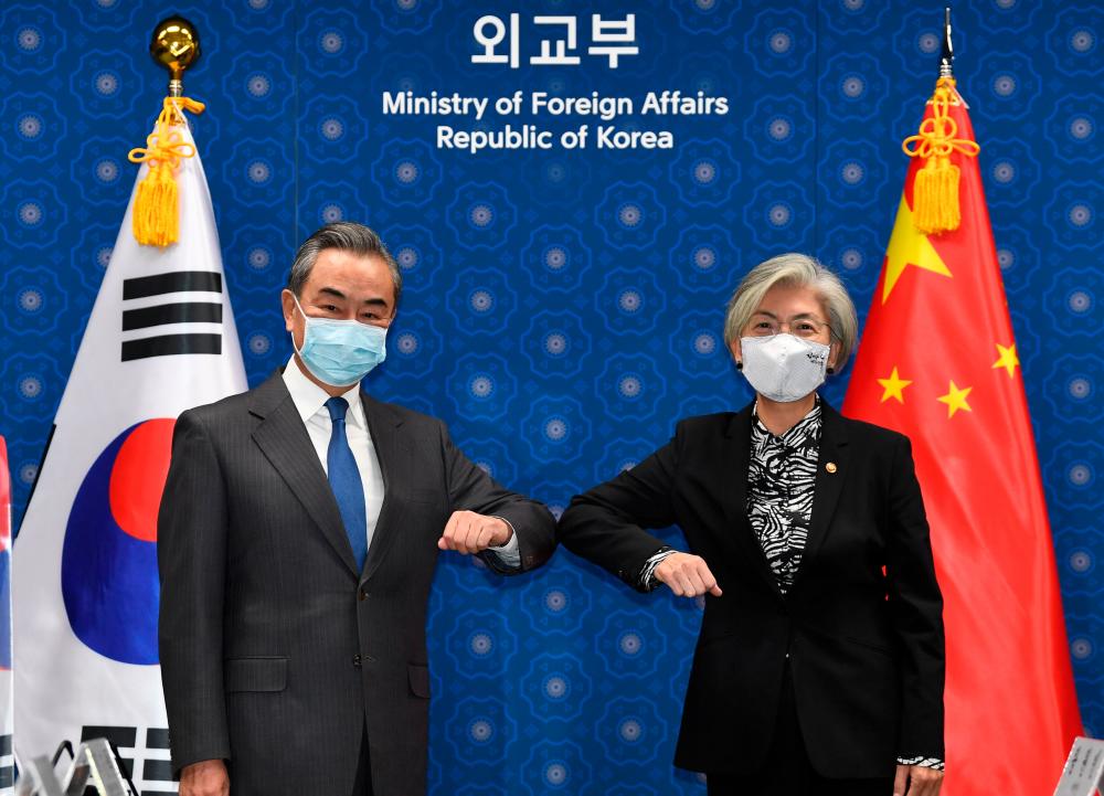 Chinese Foreign Minister Wang Yi (L) and South Korean Foreign Minister Kang Kyung-wha (R) greet prior to their meeting at the foreign ministry in Seoul, South Korea, November 26, 2020. — Reuters