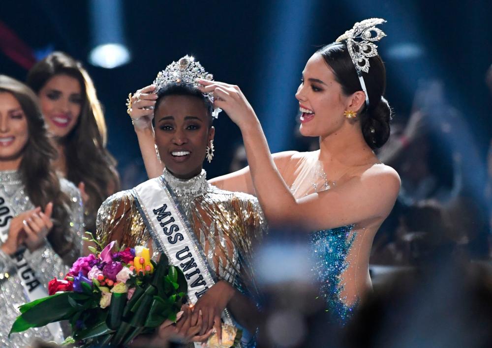 Miss Universe 2018 Philippines' Catriona Gray (R) crowns the new Miss Universe 2019 South Africa's Zozibini Tunzi on stage during the 2019 Miss Universe pageant at the Tyler Perry Studios in Atlanta, Georgia on December 8, 2019. - AFP