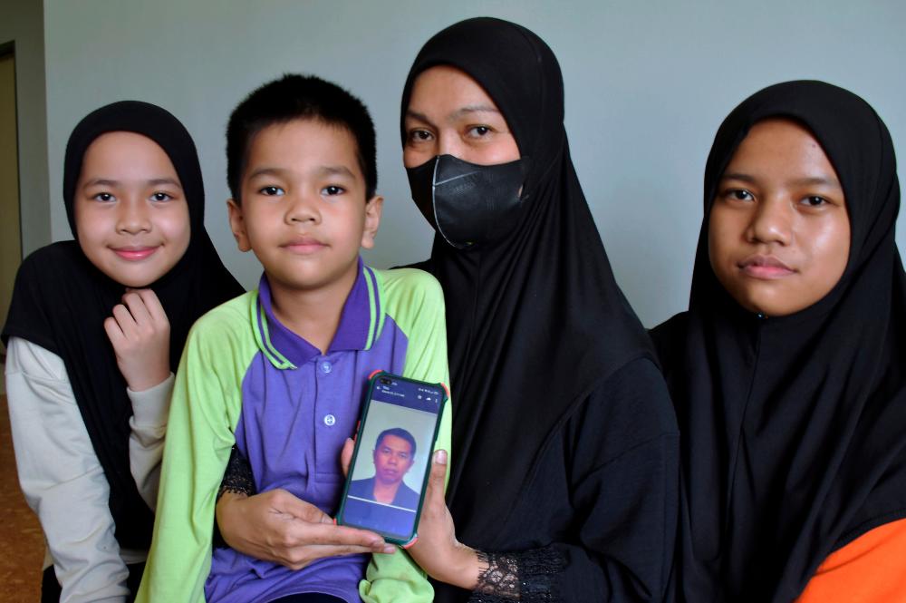 Nurulasikin Ismail bersama tiga daripada enam anaknya menunjukkan gambar arwah suaminya, Saifulnizam Razak, yang meninggal dunia akibat penyakit asma kronik/BERNAMAPix