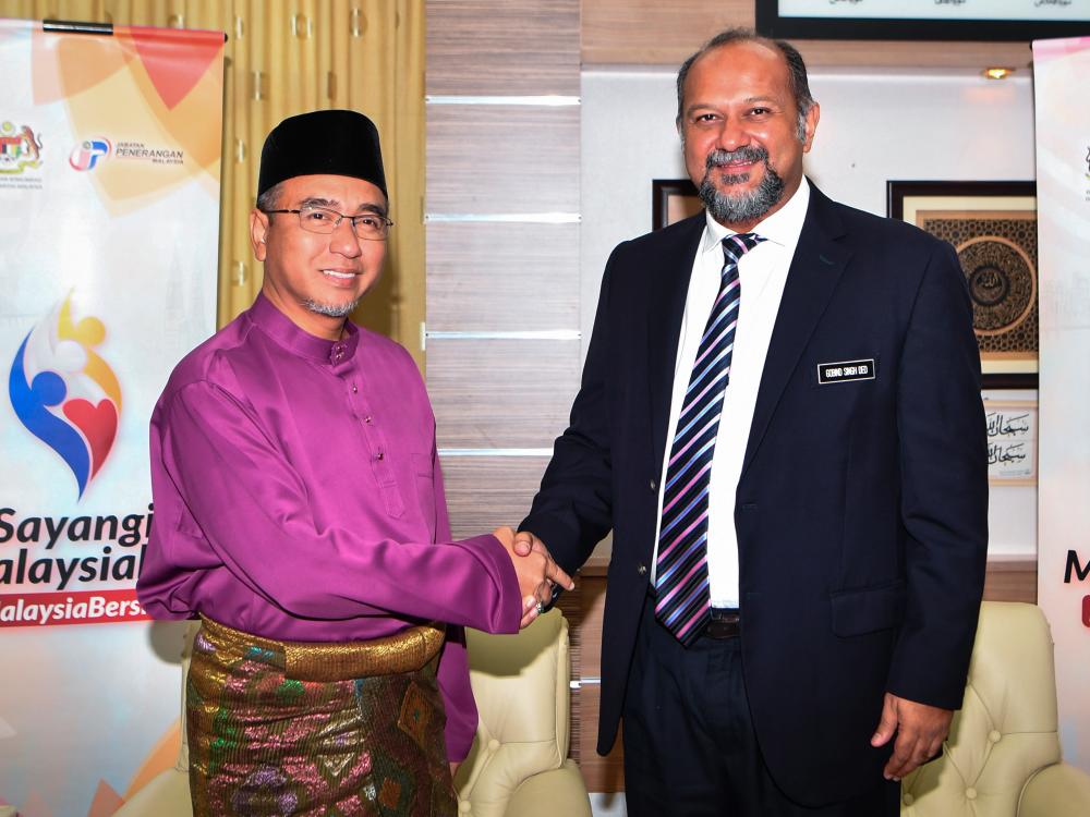 Communications and Multimedia Minister Gobind Singh Deo greets Malacca Chief Minister Adly Zahari during a visit to Seri Negara today. - Bernama
