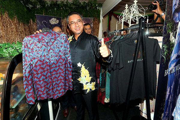 Ketua Menteri Melaka Adly Zahari memberikan tanda bagus untuk pakaian bercorak batik dari Melaka yang dipamerkan di galeri selepas Pelancaran Batik Melaka sempena ‘The Grand Cultural Festival Melaka River’ semalam. — Bernama