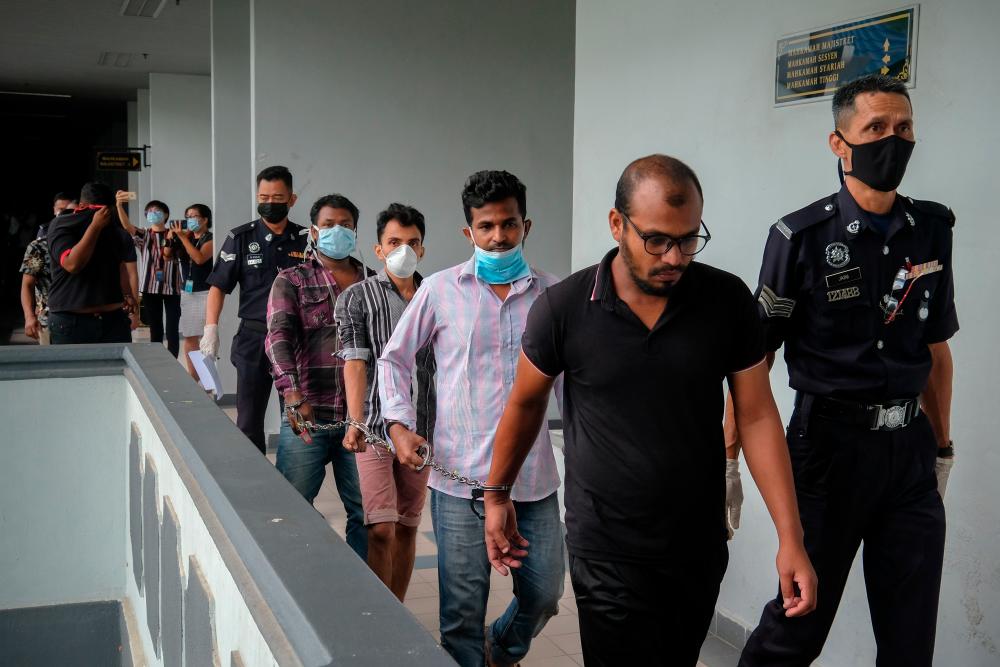 Seventeen men in Malacca are led to the court to be charged for various MCO violations, on April 2, 2020. — Bernama