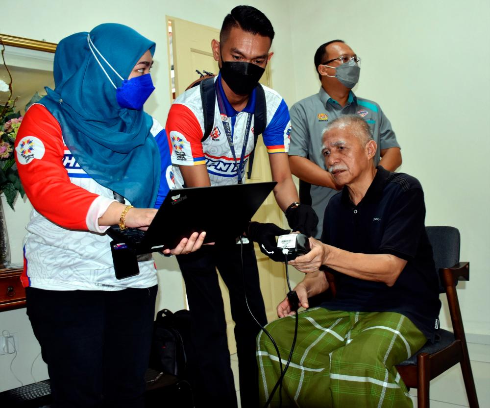 ALOR GAJAH, Feb 9 - Melaka National Registration Department (JPN) staff obtained the fingerprint of a senior citizen who suffered a stroke, Omar Md Dom, 62, (right) for the new MyKad application process at the JPN Menyemai Kasih Rakyat (Mekar) Program at his home in Taman Pengkalan Indah today. BERNAMApix