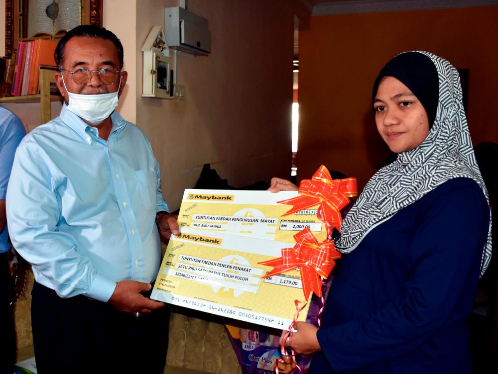 State Unity, Community Relations, Human Resource and Consumer Affairs Committee chairman Datuk Ismail Othman (L) hands over mock cheques to Nurulasyikin Mohd Ali, 32 at Taman Wira Indah Lubok China, Masjid Tanah today. — Bernama
