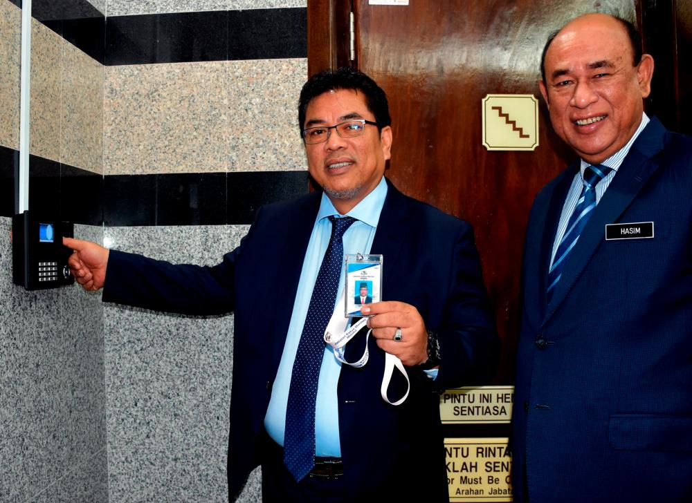 Newly appointed Chief Minister Datuk Sulaiman Md Ali (L) started work today after a symbolic gesture of clocking-in at about 8.25am at Seri Negeri. - Bernama