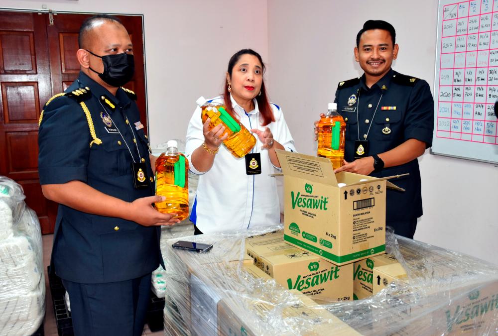 MELAKA, August 10-- Director of the Ministry of Domestic Trade and Consumer Affairs (KPDNHEP) Melaka Norena Jaafar (centre) shows some bottled cooking oil at a press conference today. BERNAMAPIX
