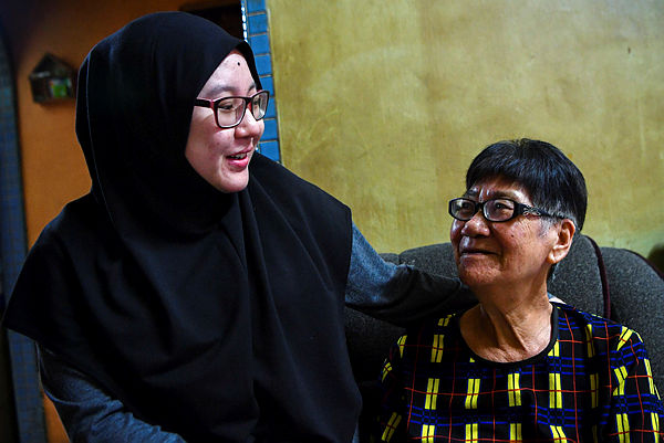 Recipient of the Malacca Excellent Mother Award 2015, Tan Guan Neo (right) and her granddaughter Fahira Nabihah Isham during an interview session at her home in Malacca, today — Bernama