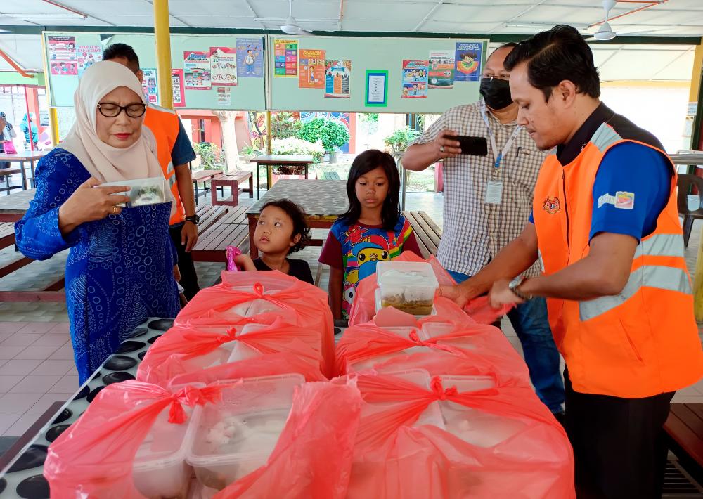 JASIN, March 8 -- State Exco for Women’s Affairs, Family Development and Welfare Datuk Kalsom Noordin (left) inspects the food that will be supplied to flood victims at the temporary evacuation center (PPS) when visiting Sekolah Kebangsaan (SK) Sungai Rambai today. BERNAMAPIX