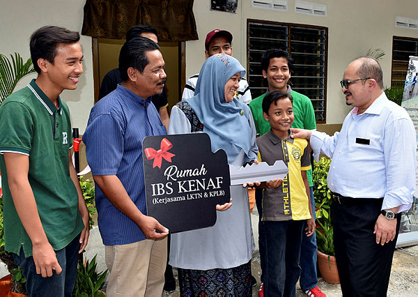 Primary Industries Deputy Minister Datuk Seri Shamsul Iskandar Mohd Akin (right) speaking to a family who received aid in building their home using kenaf-based IBF technology at Kampung Solok Punggai yeseterday. — Bernama
