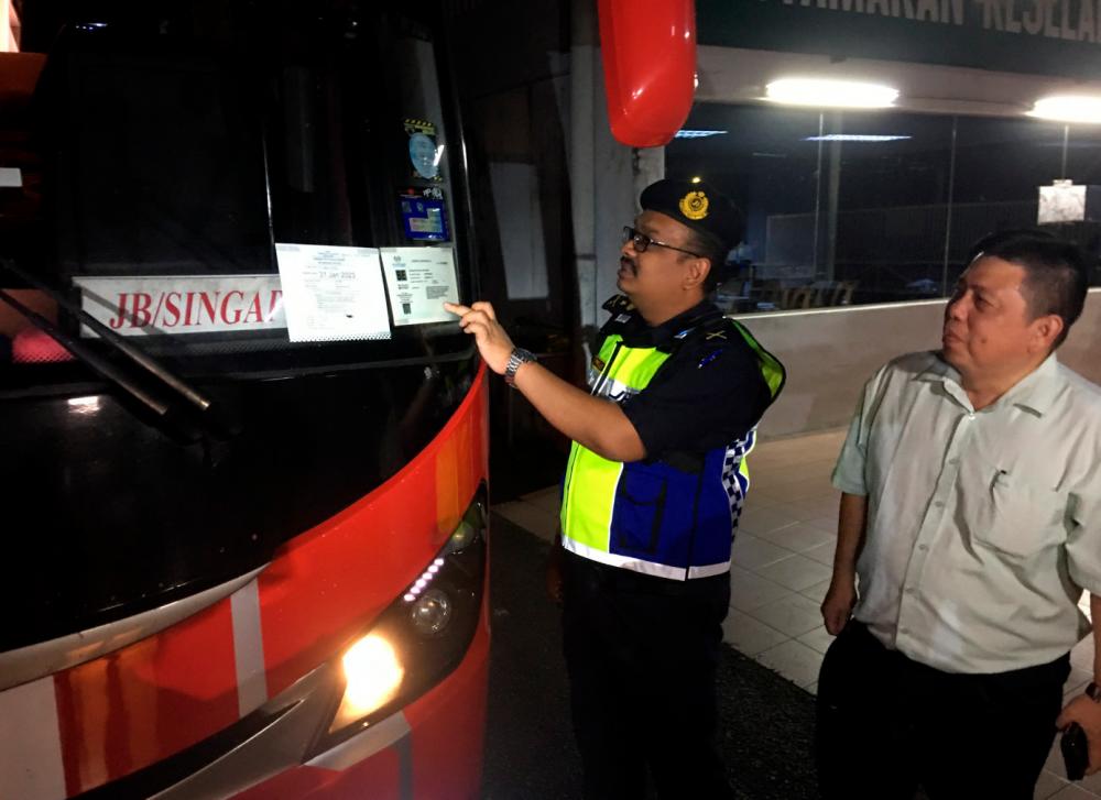 Pengarah Jabatan Pengangkutan Jalan (JPJ) Melaka, Muhammad Firdaus Shariff (kiri) memeriksa dokumen dan cukai jalan bas ekspress dalam Op Depoh sempena sambutan Tahun Baru Cina/BERNAMAPix