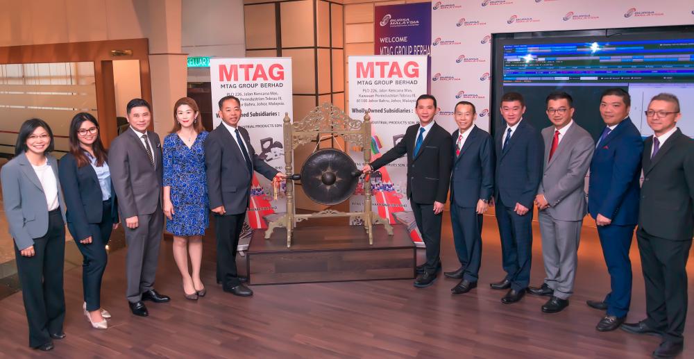 Managing director Chaw Kam Shiang (fifth from left) and and executive director Philip Lau Cher Liang hitting the gong at the company’s listing ceremony today.