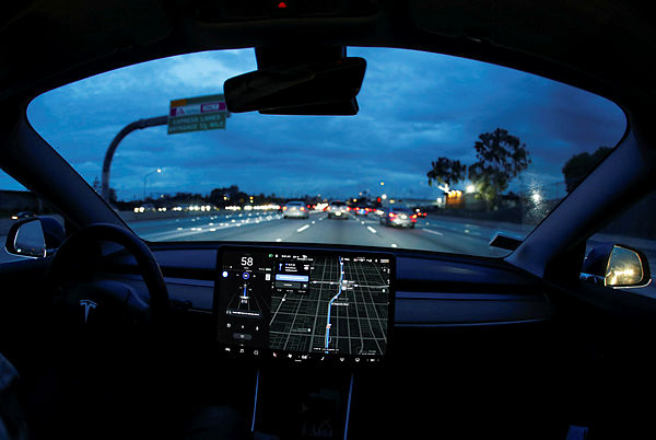 A Model 3 Tesla vehicle navigates morning rush hour using the car’s auto pilot feature in Los Angeles — Reuters
