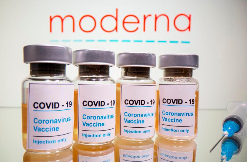 Vials with a sticker reading, “Covid-19 / Coronavirus vaccine / Injection only” and a medical syringe are seen in front of a displayed Moderna logo in this illustration taken October 31, 2020. — Reuters