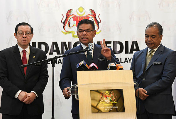 Domestic Trade and Consumer Affairs Minister Datuk Seri Saifuddin Nasution Ismail (C) together with Finance Minister Lim Guan Eng (L). — Bernama