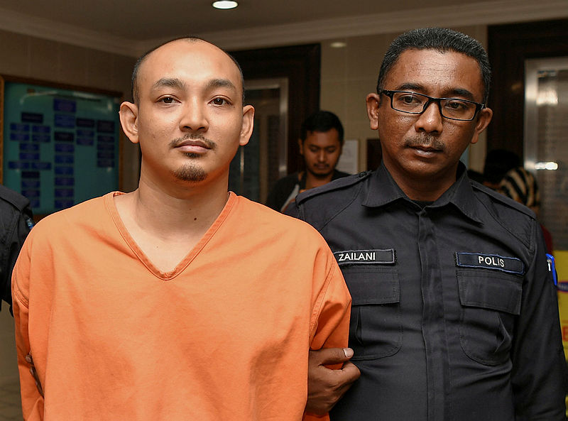 Mohd Nasli Mohd Nasir (L) is led out of the Kuala Terengganu sessions court, on Aug 22, 2019. — Bernama