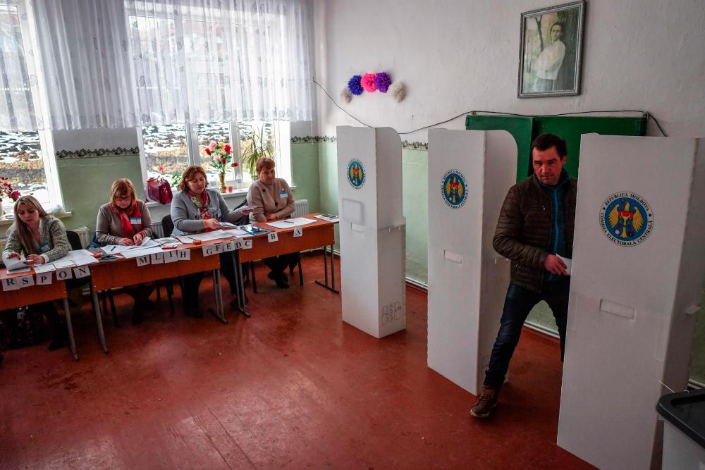 A man leaves a polling booth at a polling station in Pojareni village, on Feb 24, 2019, as Moldovans are called to the polls to elect new parliament members. — AFP