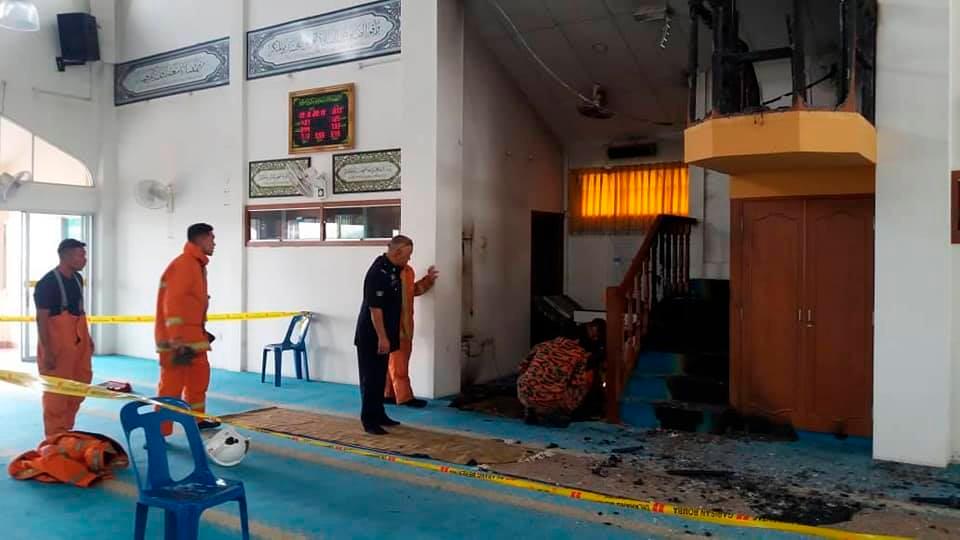 Officers from the Padang Terap Fire and Rescue Department, at the Padang Setol Mosque, after the rostrum and carpet were set on fire by an arsonist, on Aug 19, 2019. ù Facebook pix courtesy of Denaihati News