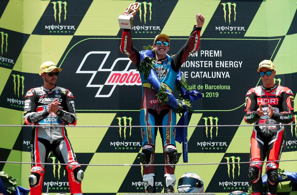EG 0,0 Marc VDS's Spanish rider Alex Marquez (C) celebrates on the podium next to Dynavolt Intact's Swiss rider Thomas Luthi (L) and Beta Tools Speed Up's Spanish rider Jorge Navarro (R) after winning the Catalunya Moto2 Grand Prix race at the Catalunya racetrack in Montmelo, near Barcelona, on June 16, 2019. — AFP
