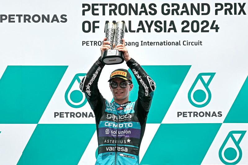 CFMOTO Aspar Team's Colombian rider David Alonso celebrates victory on the podium after the Moto3 race of the MotoGP Malaysian Grand Prix at the Sepang International Circuit in Sepang on November 3, 2024. - Lillian SUWANRUMPHA / AFP
