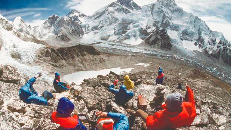 A group of tourists enjoy the view of the Everest from the Kala Patthar landmark peak.