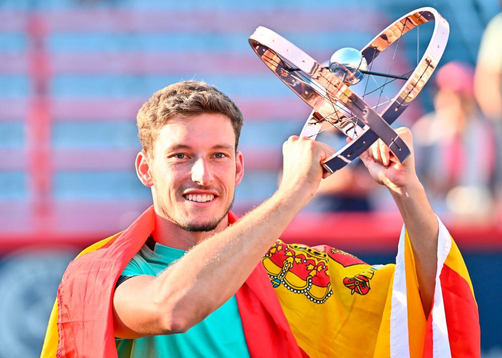 MONTREAL, QUEBEC - AUGUST 14: Pablo Carreno Busta of Spain holds up the National Bank Open trophy after defeating Hubert Hurkacz of Poland in the final round during Day 9 of the National Bank Open at Stade IGA on August 14, 2022 in Montreal, Canada. Pablo Carreno Busta defeated Hubert Hurkacz 3-6, 6-3, 6-3. AFPPIX