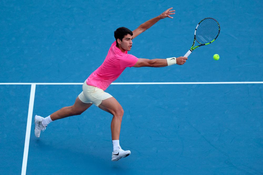 MIAMI GARDENS, FLORIDA - MARCH 26: Carlos Alcaraz of Spain plays a backhand volley against Dusan Lajovic of Serbia in their third round match at Hard Rock Stadium on March 26, 2023 in Miami Gardens, Florida. AFPPIX