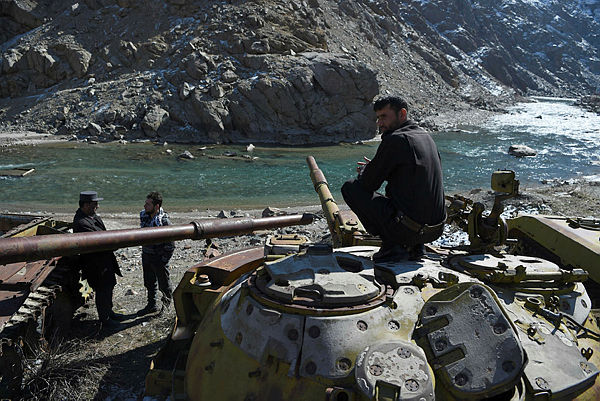 This photo taken on February 7, 2019 shows Afghan police gathering near the remains of Soviet-era tanks in Panjshir Province, north of the capital Kabul. — AFP