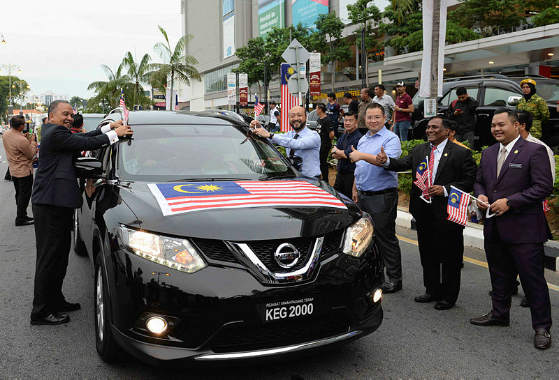 Kedah Mentri Besar Datuk Seri Mukhriz Tun Mahathir (5th L) and Deputy Finance Minister Datuk Ir Amiruddin Hamzah stick the national flag on a vehicle during launch of the state-level ‘Fly the Jalur Gemilang’ campaign, on Aug 7, 2019. — Bernama